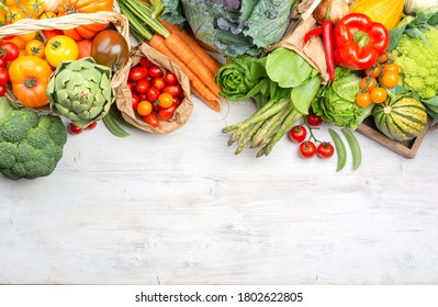 Fresh vegetables on white wooden table. Healthy food, tomatoes pepper kale broccoli peppers parsley cabbage asparagus, top view, selective focus