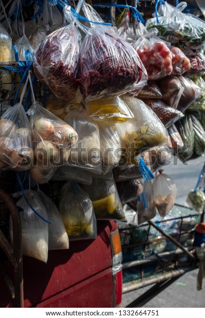 Fresh\
vegetables packed in plastic bags hung around the back of mini van.\
This van is a moveable fresh market for people living in village. A\
delivery fresh market for a modern urban\
society.