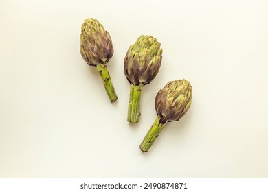 Fresh vegetables - raw artichokes. Green and purple artichoke flower buds.