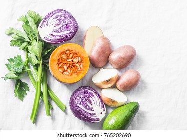 Fresh vegetables - red cabbage, potatoes, onion, celery, pumpkin and avocado on a light background, top view. Clean eating concept