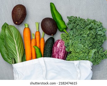 Fresh Vegetables In Reusable Shopping Bag Top View. Sustainable Living And Healthy Eating. Green Leaf Veggies As Kale And Chard With Avocado, Carrot And Green Pepper. Organic And Zero-waste Grocery