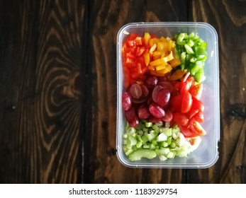 Fresh Vegetables Salad And Fruits In A Plastic Container, Ingredients For Making Pasta Salad On A Wooden Table.