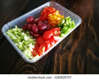 Fresh Vegetables Salad And Fruits In A Plastic Container, Ingredients For Making Pasta Salad On A Wooden Table.