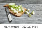 Fresh Vegetables, sliced young bottle gourd or Lagenaria siceraria on wooden cutting board. Isolated on gray wood texture background. Suitable for design element, preparing food concept. 