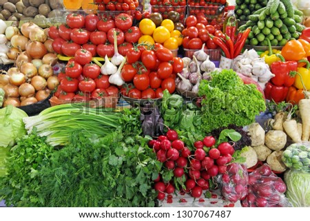 fresh vegetables tomatoes, onions,greens, parsley, dill, salad, onion, radish, chili and garlic on a market place colorful