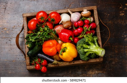 Fresh vegetables in wooden box on wooden background