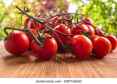 Fresh Vine Of Cherry Tomatoes On A Wooden Kitchen Board Low Angle Macro Close Up Shot Outside Shallow Depth Of Field.