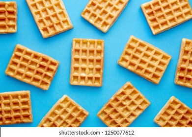 Fresh waffles pattern isolated on a blue background viewed from above. Top view