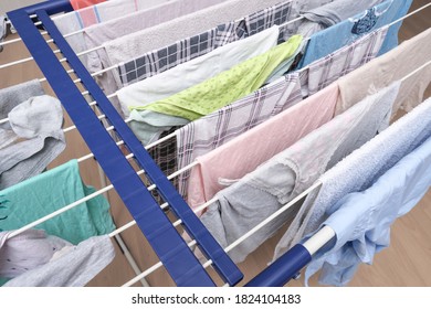 Fresh Washed Linen, Clothes Hanging On A Dryer, Dry Apparel On A Folding Portable Dryer Close Up, Housekeeping, Homework And Chores Concept.