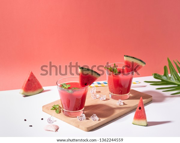 Fresh water melon juice and watermelon slice on\
red background. summer\
drink.