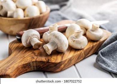 Fresh white champignon mushrooms on cutting board. - Powered by Shutterstock