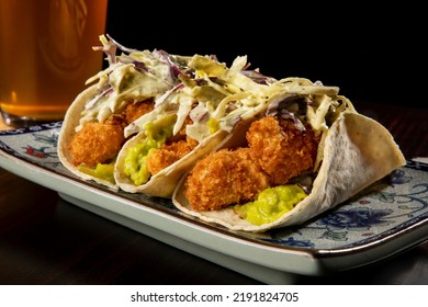 Fresh White Fish Tacos With Coleslaw, Salsa And Lime Crema In A Flour Tortilla On A Plate