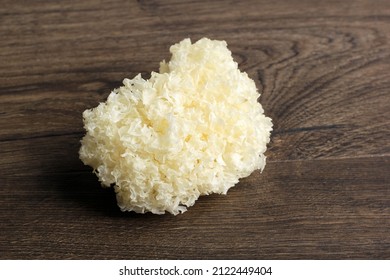 Fresh White Fungus (Tremella fuciformis) on Brown Wooden Table, Isolated
