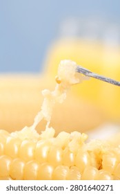 Fresh white sticky corn kernels with aromatic steam rising, knife cutting through cob on golden background, Xishuangbanna region specialty food ingredient