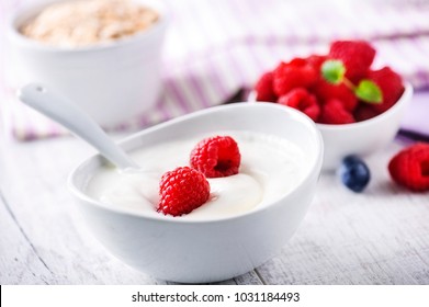 Fresh white yoghurt with raw forest fruits. Rasberries in white yoghurt in bowl on white table. Best meal for healthy breakfast. - Powered by Shutterstock