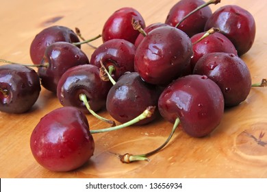 Fresh whole cherries with stalk on wooden background