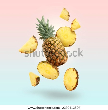 Fresh whole and cut pineapples falling on colorful background