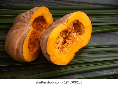 Fresh Whole Pumpkin Vegetable Cut In Half , Large Raw Ripe Orange Pumpkin Sliced Isolated On Palm Leaves. Winter Squash From Farm Harvested In Kerala India