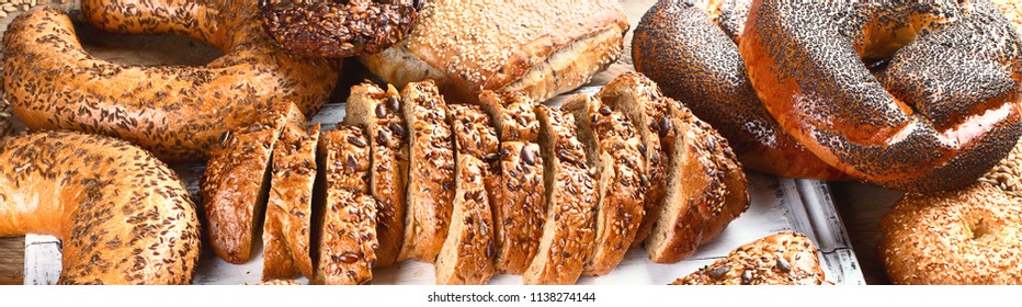 Fresh wholegrain mixed bread on rustic wooden table. Panorama