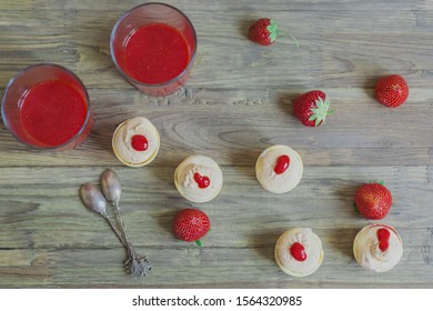 Fresh wholesome strawberry smoothie or juice in glass and meringue cream with fresh strawberries in waffle cup on white plate on wooden background. Food photo. Top view - Powered by Shutterstock