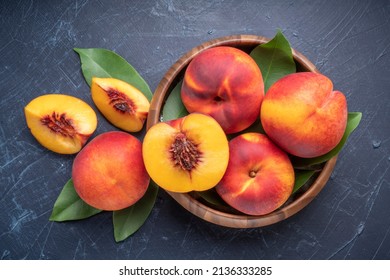 Fresh Yellow Peach fruit in wooden bowl on wooden background, Yellow Peach with slice in wooden basket.