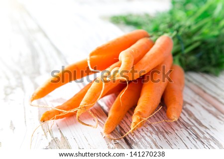 Fresh young carrots on wooden background
