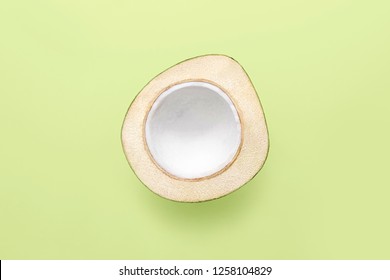 Fresh young coconut on a green background, creative flat lay healthy food concept, top view with clipping path
