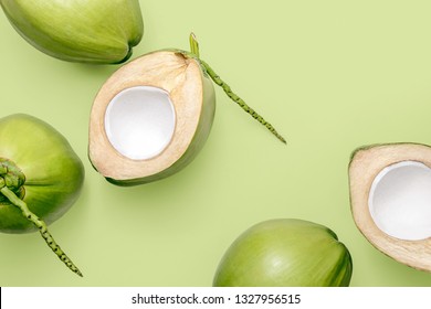Fresh young coconuts on a pastel green background, creative flat lay healthy food concept