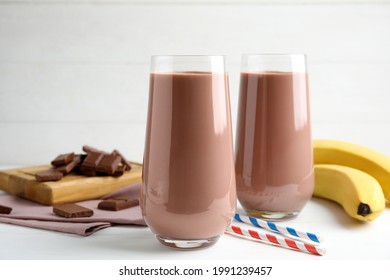 Fresh yummy chocolate milk on white wooden table