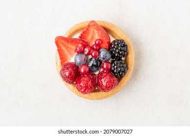 Freshly backed tartlet with strawberries, blueberries, raspberries on beige stone background. Top view, flat lay of food photography minimal concept. - Powered by Shutterstock