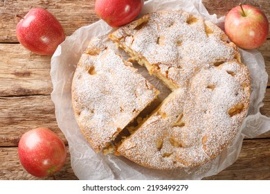 Freshly baked apple pie charlotte sprinkled with powdered sugar close-up on an old wooden table. horizontal top view from above - Shutterstock ID 2193499279