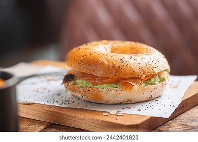 Freshly baked bagel topped with cream cheese, smoked salmon, sprinkled with seeds, set on rustic wooden tabletop near a leather couch. - Powered by Shutterstock