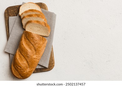 Freshly baked bread slices on cutting board against white wooden background. top view Sliced bread. - Powered by Shutterstock