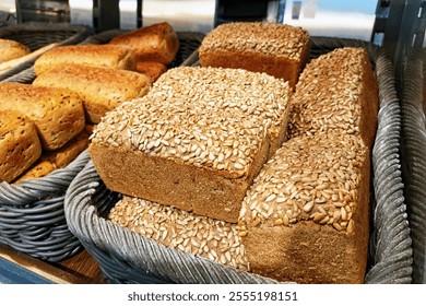 Freshly baked bread in wicker baskets. Variety of loaves in a bakery. Artisanal bread selection. Bread shop with handmade baked goods. Rustic bread display. Traditional baking background. - Powered by Shutterstock