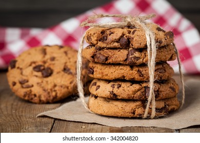 freshly baked chocolate chip cookies on rustic wooden table - Powered by Shutterstock