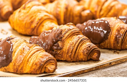 Freshly baked chocolate croissants on a baking tray  - Powered by Shutterstock