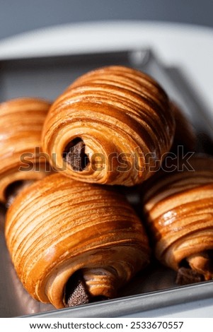Freshly baked chocolate croissants on a tray, showcasing golden-brown layers and tempting filling, perfect for breakfast or a snack