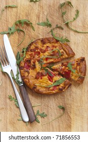 Freshly Baked Chorizo Tortilla Topped With Rocket On A Wooden Board