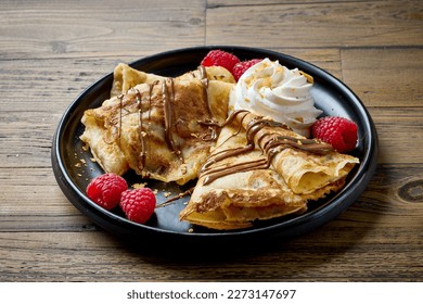 freshly baked crepes decorated with raspberries and whipped cream - Powered by Shutterstock