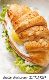 Freshly Baked Croissant Sandwich With Fried Egg, Ham, Cheese And Lettuce. Healthy Delicious Breakfast. Overhead View, Close Up