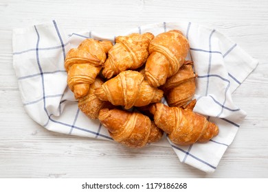 Freshly Baked Croissants On Cloth On White Wooden Table, Overhead View. From Above, Top View, Flat Lay. Close-up.