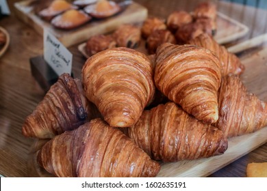 freshly baked croissants on wooden cutting board Warm Fresh Buttery Croissants and Rolls. French and American Croissants and Baked Pastries - Powered by Shutterstock