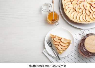 Freshly baked delicious apple pie served on white wooden table. Space for text