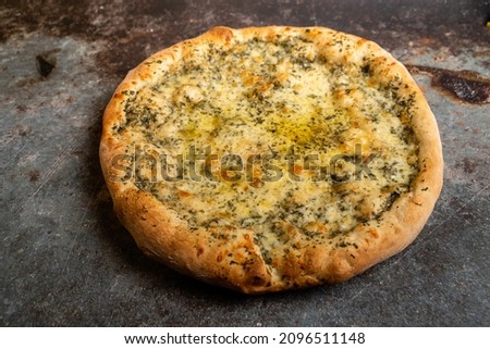 Freshly baked delicious creamy pesto pizza on a rustic background. selective focus