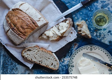 Freshly Baked Delicious Crusty Wholewheat Seed Bread With Butter Served On A Rustic Cloth  In A Country Kitchen With A Vintage Kitchen Accessories. Healthy Food Concept.