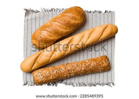Freshly baked delicious french bread with napkin isolated on white background top view. Healthy white bread loaf.