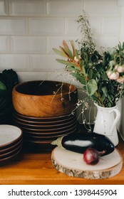 Freshly Baked Fermented Sourdough Bread With A Blue And White Kitchen Towel Resting On A Wooden Plate And Black Stove, Ready To Be Served. Still From A Typical Swedish Kitchen