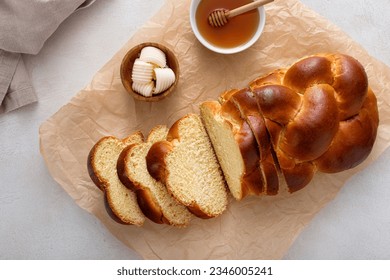 Freshly baked hallah sliced served with butter and honey, overhead shot