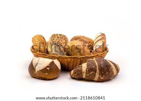 freshly baked healthy buns and crossaints in a wheat basked on an white background. seasme buns lye rod