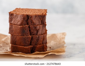 Freshly baked homemade banana chocolate loaf. Pound cake with chocolate pieces in close-up. Dessert slices on baking paper. Selective focus, copy space